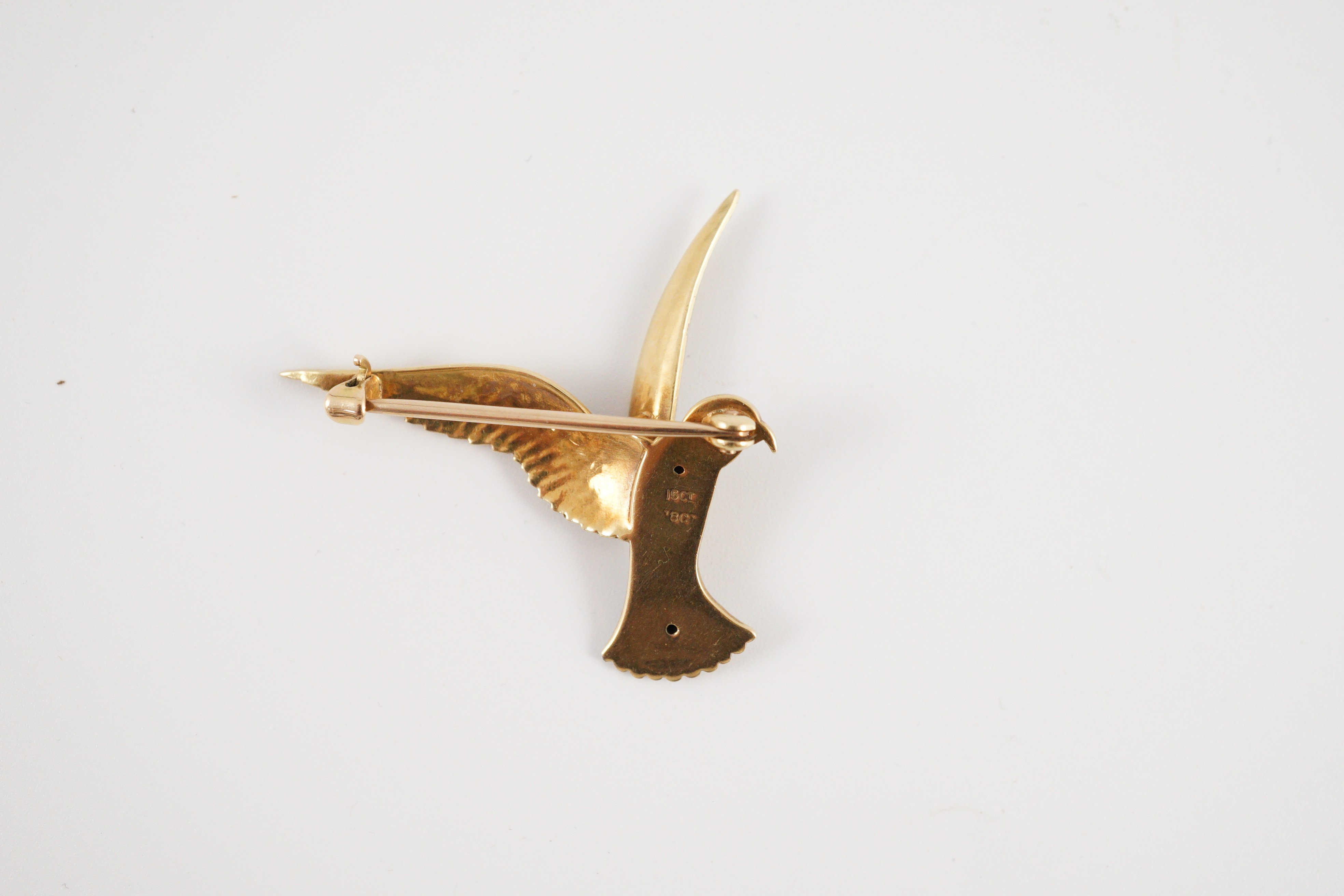 An early 20th century two colour 18ct gold, 15ct gold and enamel set brooch, modelled as a bird of prey